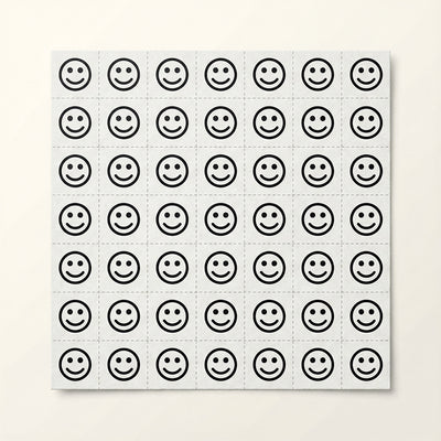 Sheet of black smiley face stickers on a white background