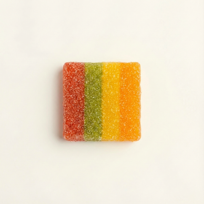 Colorful striped gummy candy on a light beige background